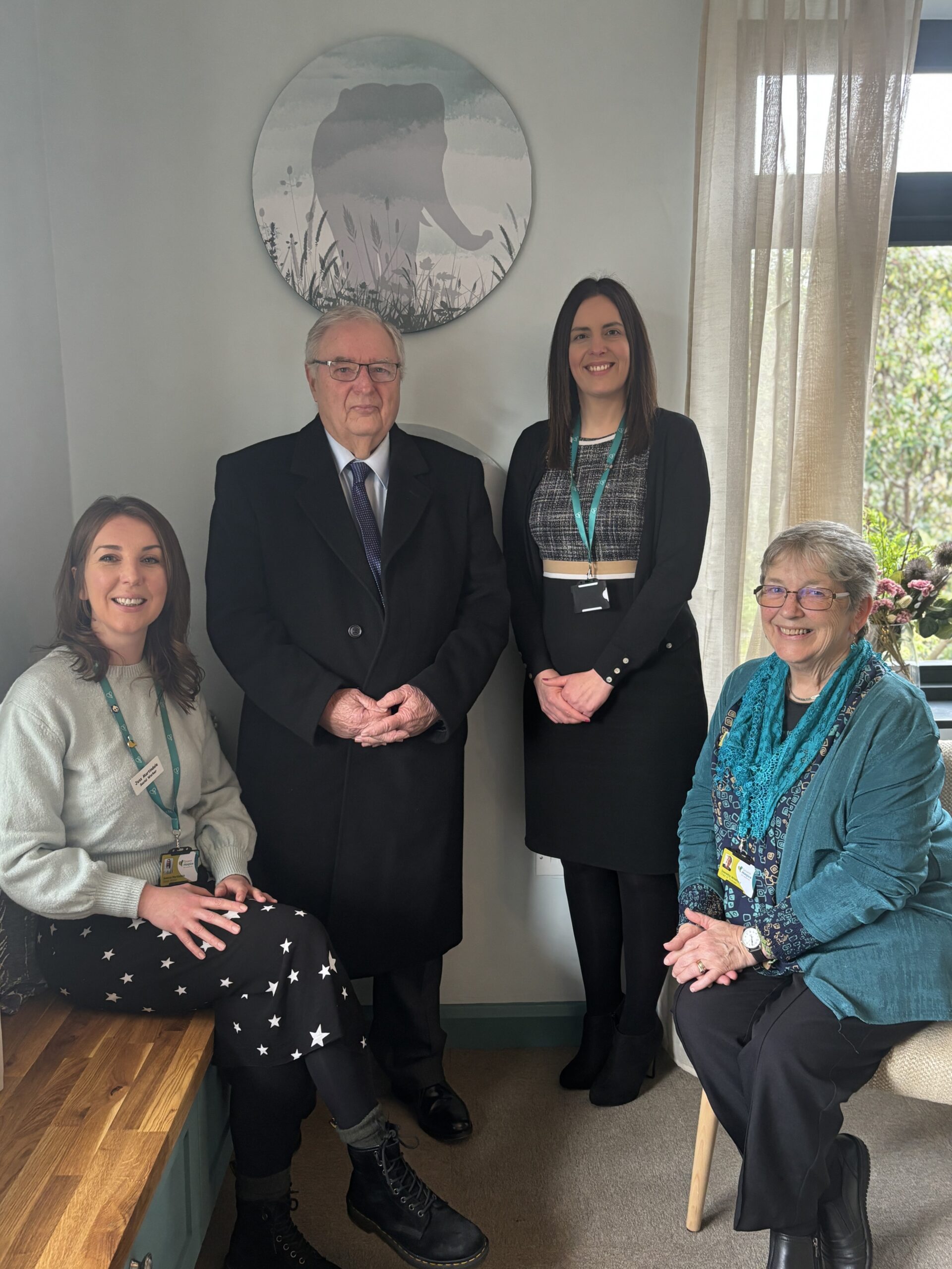 Four people, two standing and two sitting, in a bereavement room