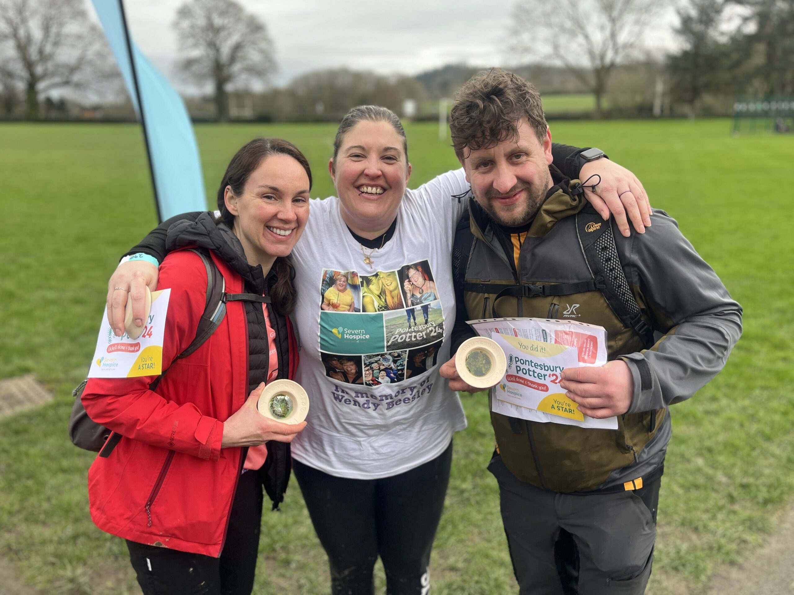 Three people standing together celebrating the end of a sponsored walk