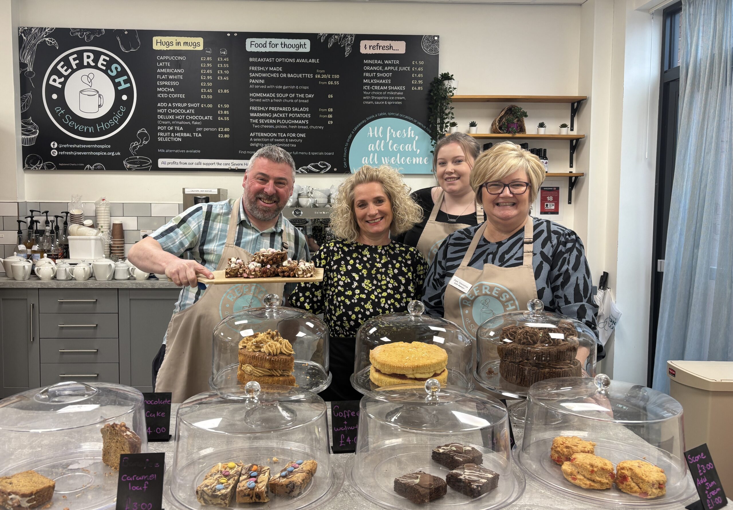 Staff members smile behind counter at Refresh cafe.